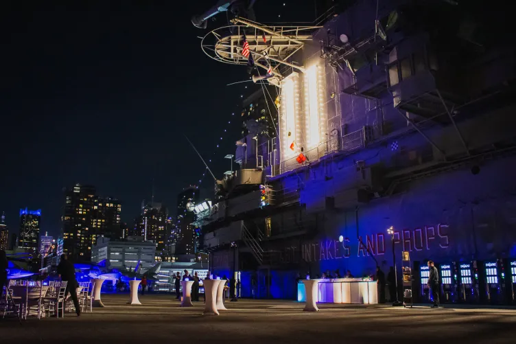 Evening Flight Deck reception with blue uplighting high top tables and a bar
